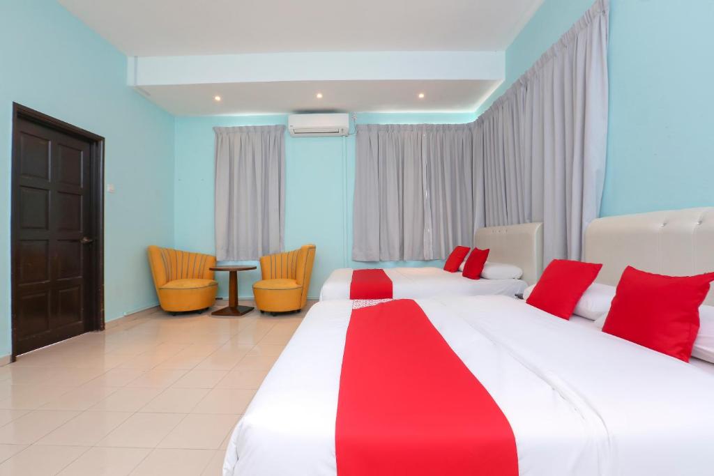 a hotel room with a large bed with red accents at Hotel O Come Inn Premium in Kuala Terengganu