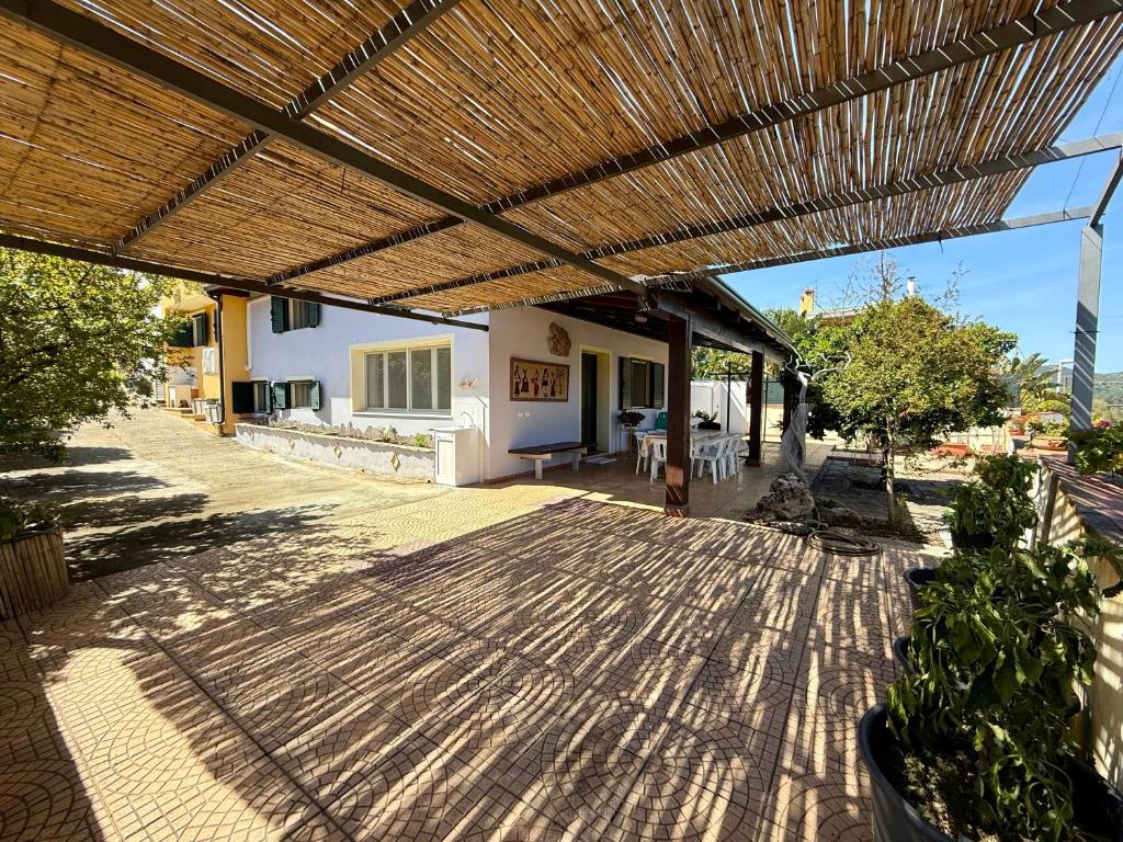 an outdoor patio with a wooden pergola at La Bomboniera XL in Bari Sardo