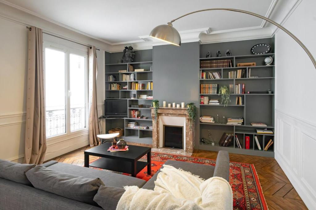 un salon avec un canapé et une cheminée dans l'établissement Apt 4 guests Place des Victoires, à Paris