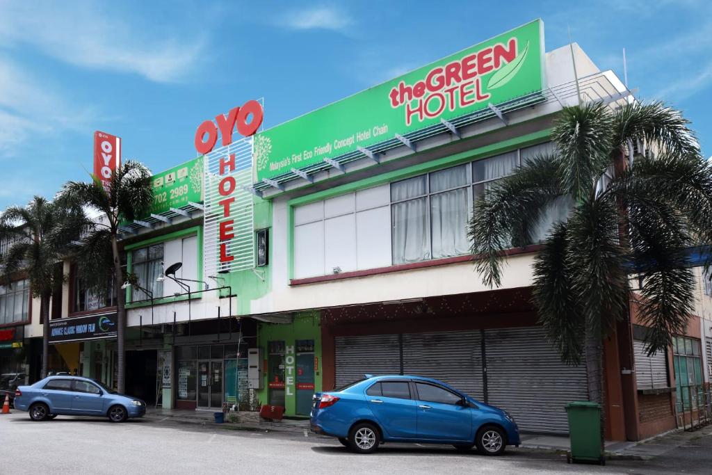 two cars parked in front of a building at OYO 479 The Green Hotel in Ampang