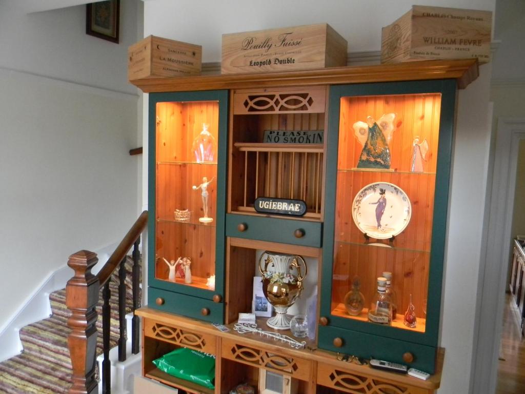 a wooden cabinet with a trophy in it at Ugiebrae House Bed & Breakfast in Seahouses