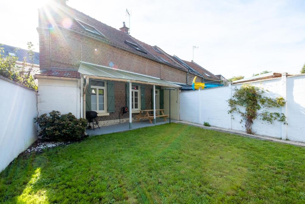 une arrière-cour d'une maison avec une pelouse dans l'établissement L'Aronnax - Maison -Jardin - Idéal Long Séjour, à Pont-de-Metz