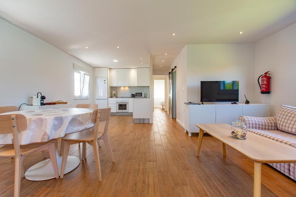 a kitchen and living room with a table and a couch at Finca Tolombreo Casa Chuchi in Cudillero