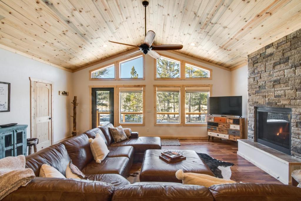 a living room with a leather couch and a fireplace at Quiet Mtn Cabin with Deck Less Than 5 Mi to Fairplay Beach! in Fairplay
