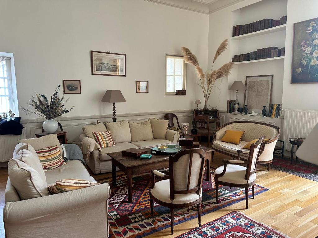 un salon avec un canapé, des tables et des chaises dans l'établissement Le plumereau ensoleillé, à Tours