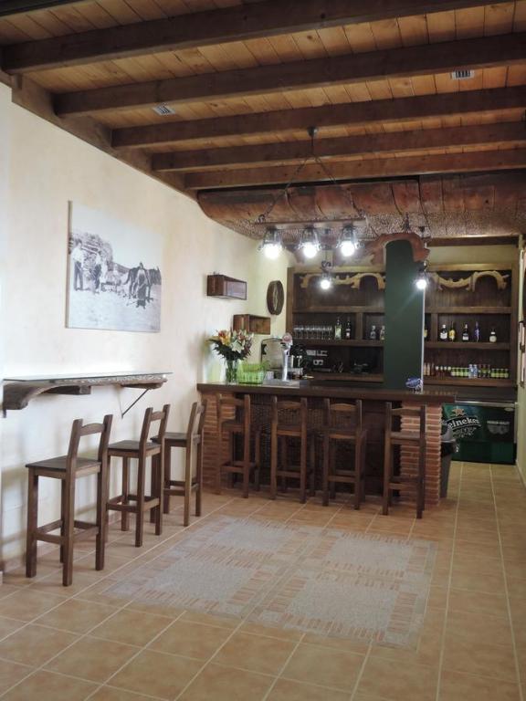 kuchnia z barem z drewnianymi stołkami w obiekcie Albergue Santo Tomás de Canterbury w mieście León