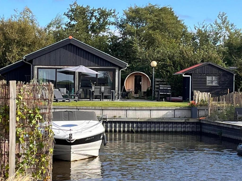 a boat is docked in front of a house at Scenic Stay with Sauna in Anjum