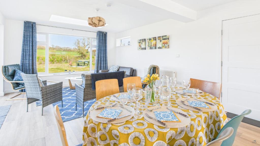 a dining room and living room with a table and chairs at Sea Breeze in Brading