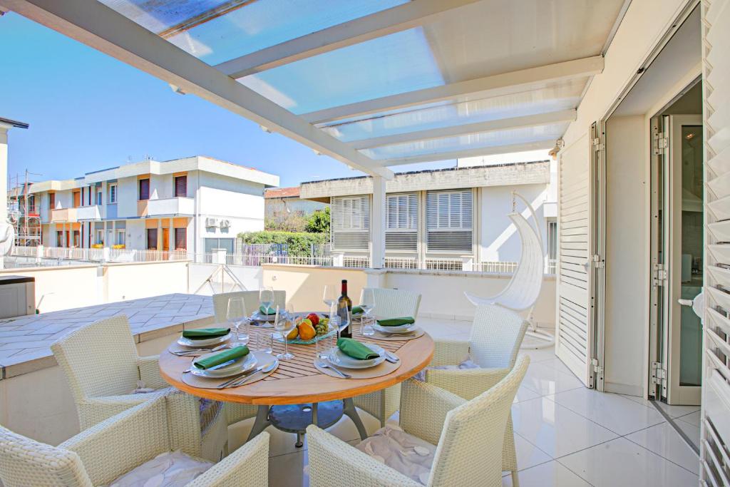 Un patio con una mesa y sillas en un balcón. en Casa Patino - Happy Rentals, en Torre del Lago Puccini