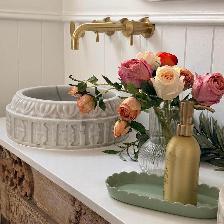 un bancone del bagno con vaso di fiori e lavandino di Studio 34 - Nelson Bay a Nelson Bay