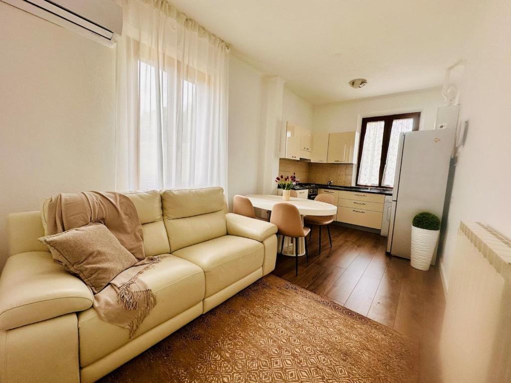 a living room with a couch and a kitchen at Siena COZY HOUSE in Siena