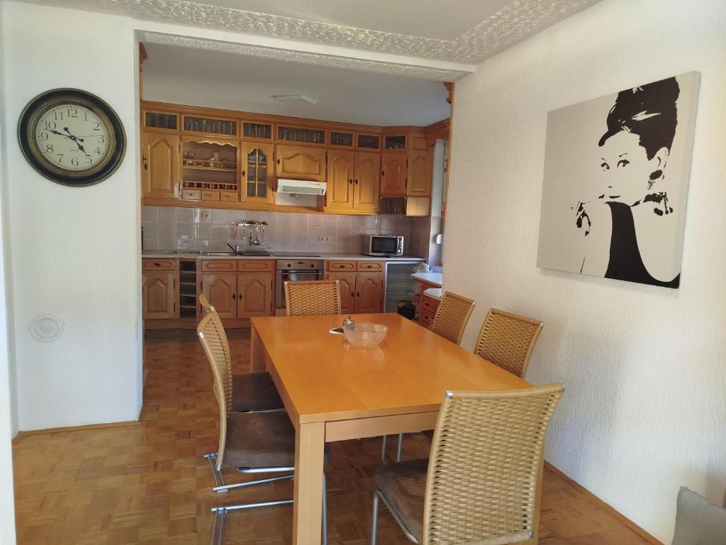 a kitchen with a wooden table and a clock on the wall at VILA RUŽA - Grand apartman 2 in Soko Banja