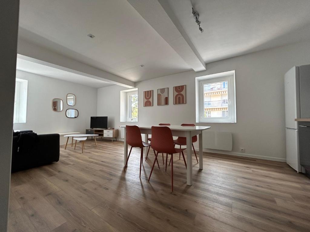 un soggiorno con tavolo e sedie di Charmant appartement au cœur de Montrond a Montrond-les-Bains