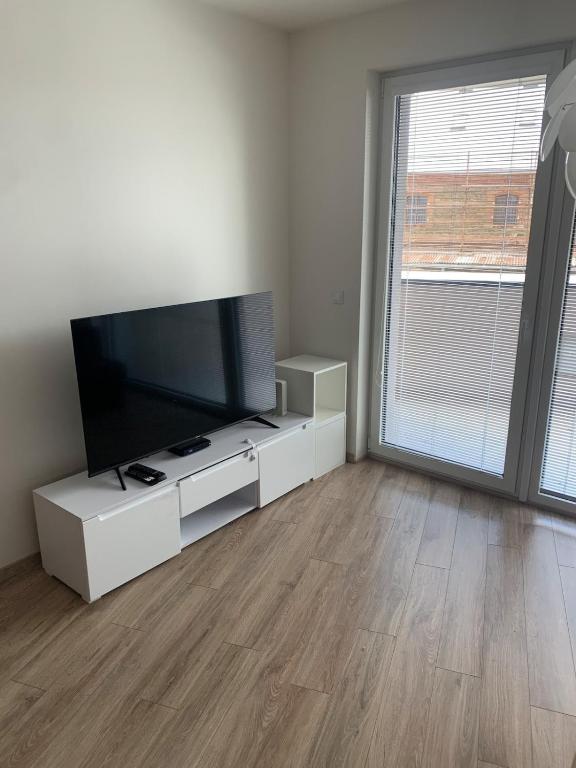 sala de estar con TV de pantalla plana en un centro de entretenimiento blanco en Your Home 14, en Košice