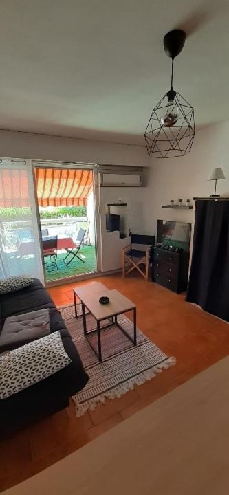 un salon avec un canapé et une table basse dans l'établissement studio cabine La Cantarelle rez de chaussée, à Bandol