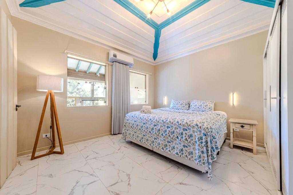 ein Schlafzimmer mit einem Bett und einer blauen Decke in der Unterkunft Relaxing & Modern House - Walking Distance from Historic Center of Paraty in Paraty