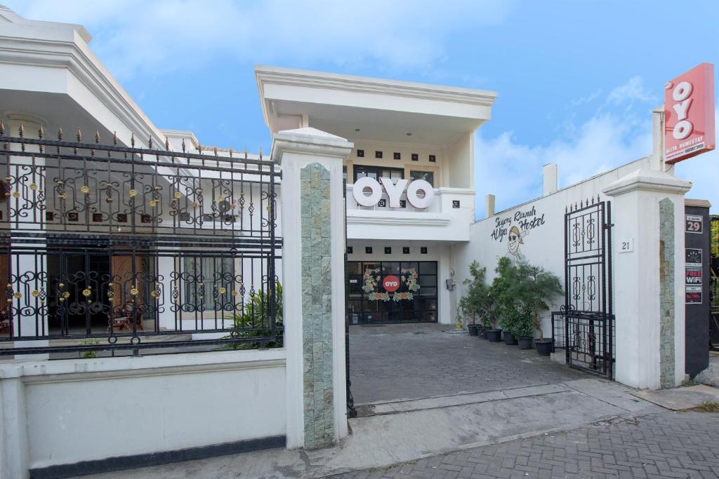 a white building with a gate in front of it at Collection O 1061 Aliya Homestay in Yogyakarta