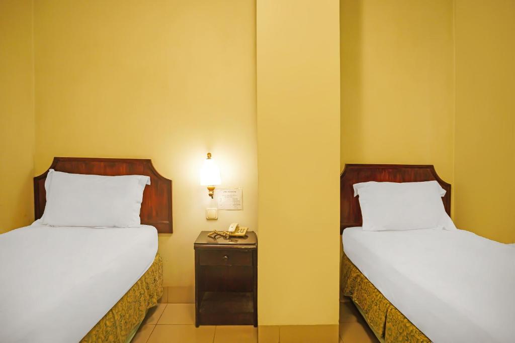 Postel nebo postele na pokoji v ubytování Super OYO Collection O 92690 Hotel Limas
