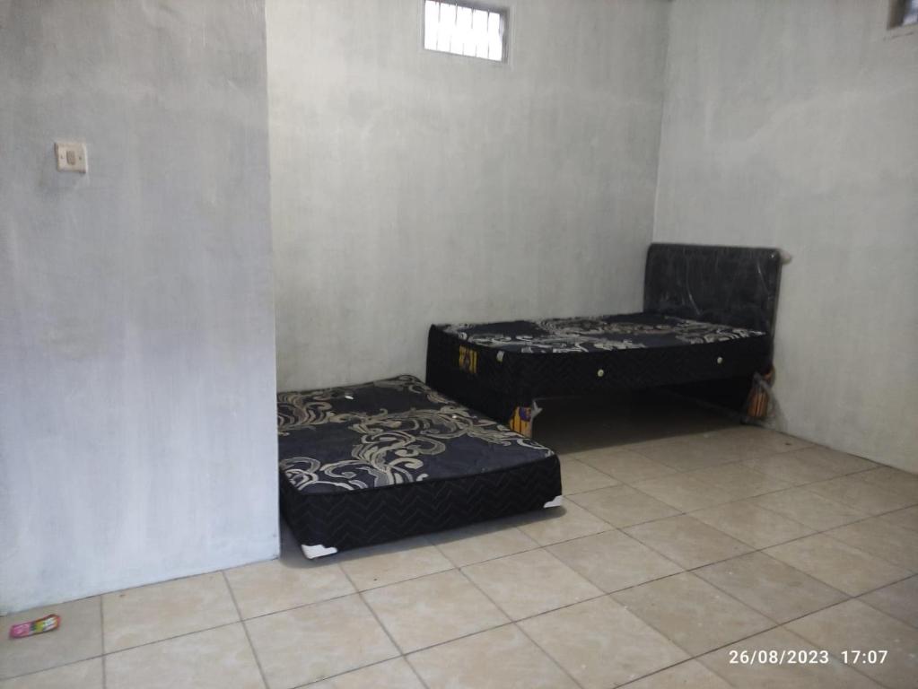 two beds sitting in a room with at Hotel O Lina Homestay Syariah in Sedati