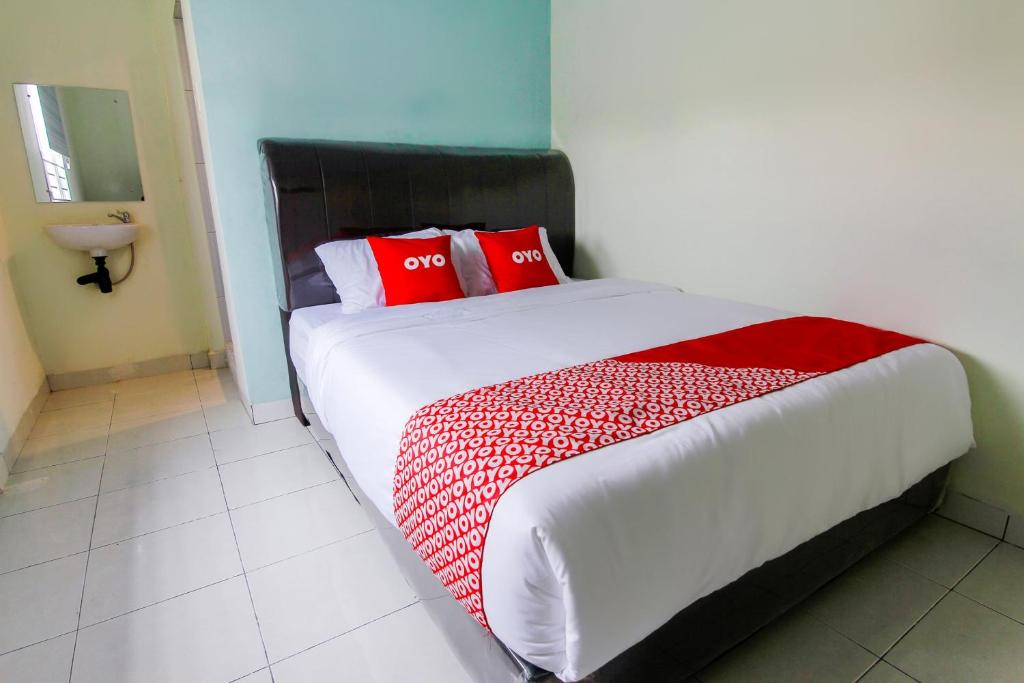 Un dormitorio con una cama grande con almohadas rojas. en Hotel O Nami House, en Medan
