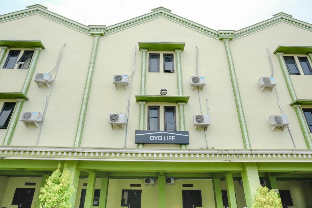 un bâtiment avec un panneau qui lit la vie confortable dans l'établissement OYO Life 2508 Alba Suites Homestay Syariah, à Tulungagung