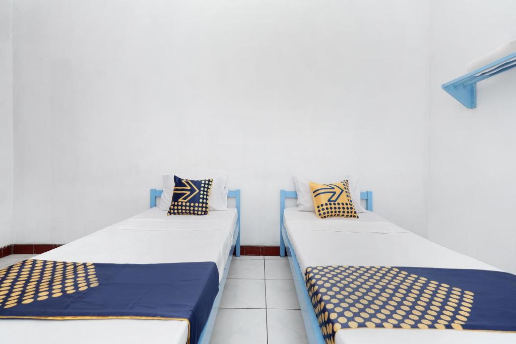 Postel nebo postele na pokoji v ubytování SPOT ON 2289 Hotel Saudara
