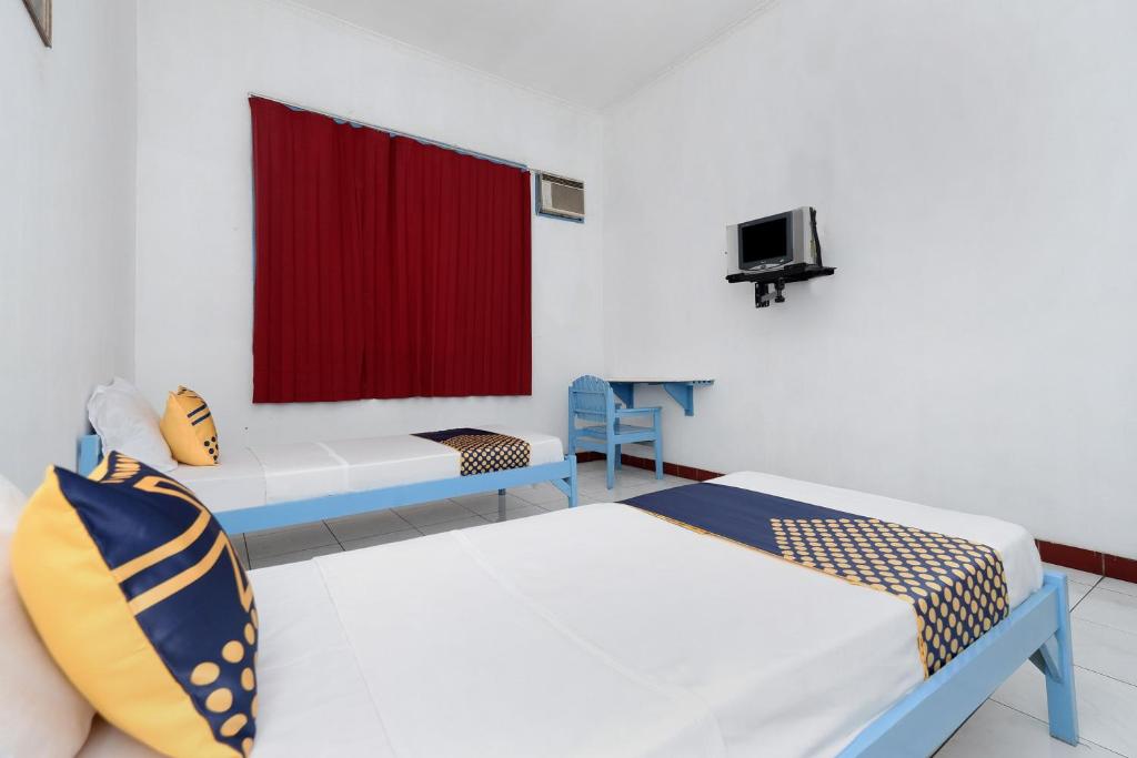 Postel nebo postele na pokoji v ubytování SPOT ON 2289 Hotel Saudara