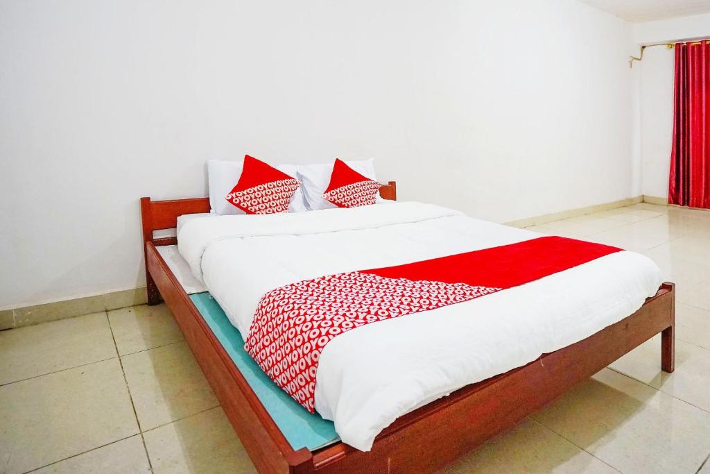 パレンバンにあるOYO Life 2820 Hotel Perdana Syariahのベッド(赤と白のシーツ、枕付)