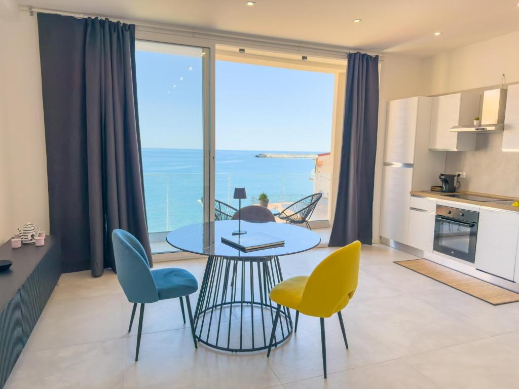 eine Küche und ein Esszimmer mit Tisch und Stühlen in der Unterkunft Casa A'mar in Giardini-Naxos