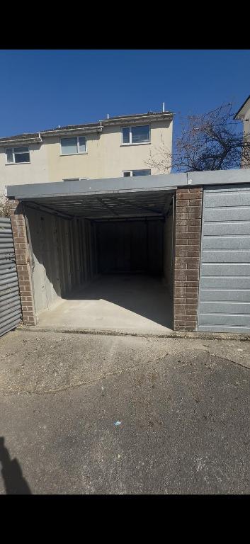 a garage with a large door in the front of a house at Bright and Spacious 2BR Maisonette Sleeps 8, Game Room, 5 mins to Brighton Beach and City Centre in Brighton & Hove