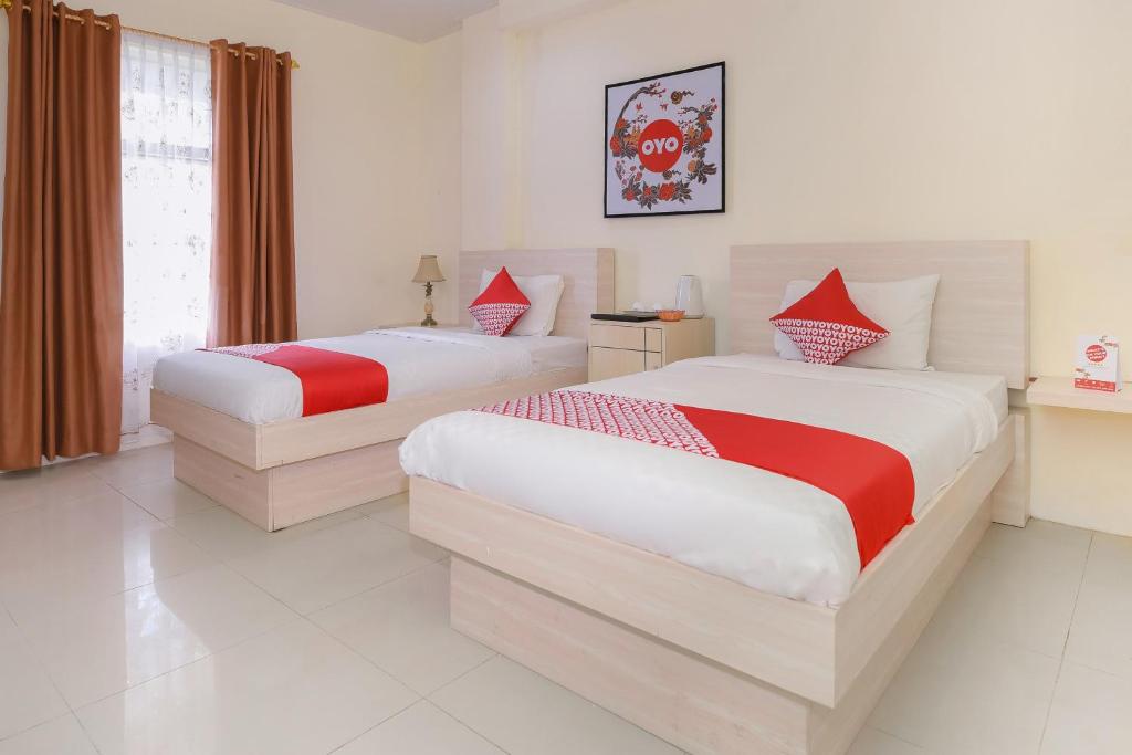 Postel nebo postele na pokoji v ubytování Capital O 854 Ub Caisar Hotel