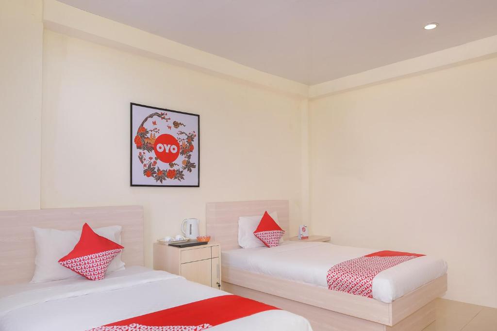 Postel nebo postele na pokoji v ubytování Capital O 854 Ub Caisar Hotel