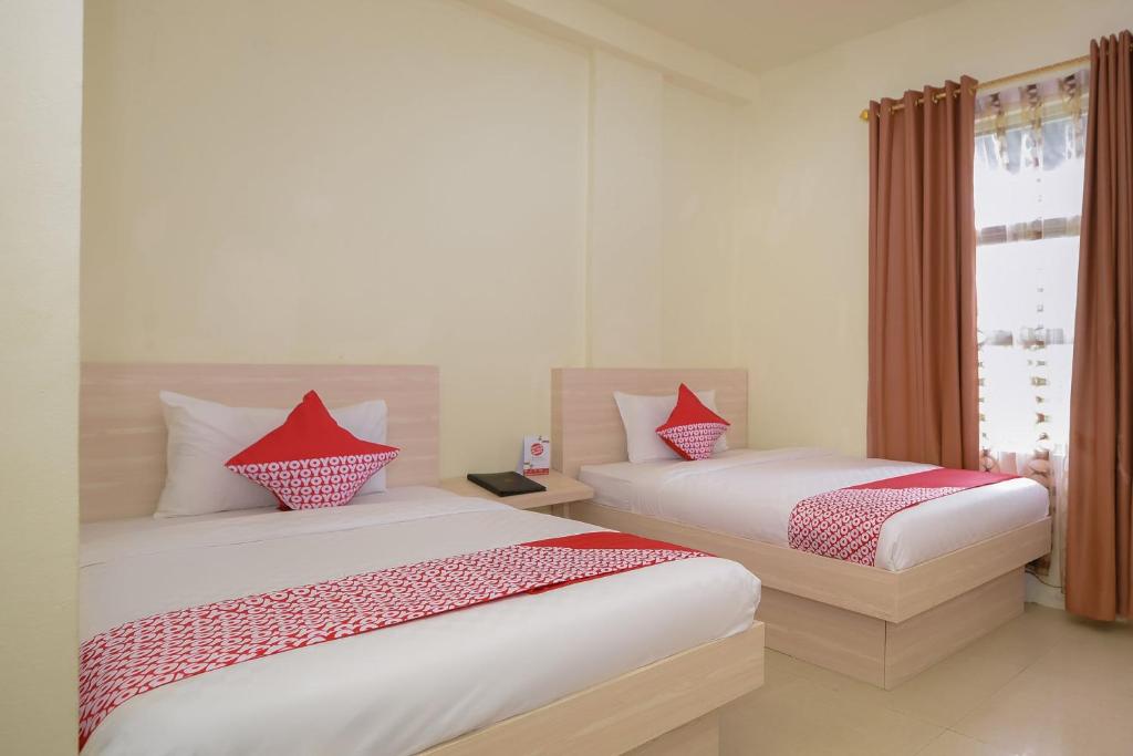 Postel nebo postele na pokoji v ubytování Capital O 854 Ub Caisar Hotel