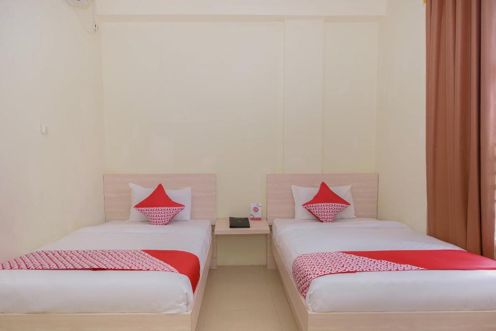 Postel nebo postele na pokoji v ubytování Capital O 854 Ub Caisar Hotel