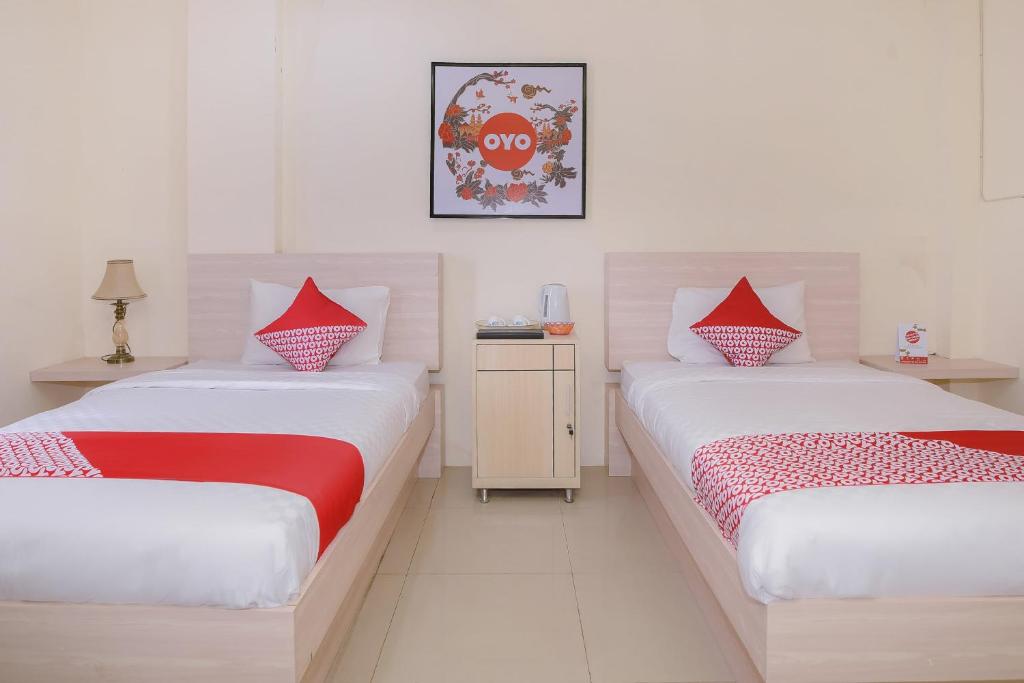 Postel nebo postele na pokoji v ubytování Capital O 854 Ub Caisar Hotel