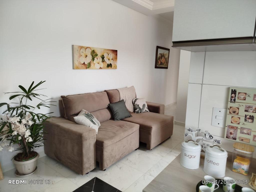 a living room with a brown couch at Apartamento à 3min do Aeroporto in São José dos Pinhais