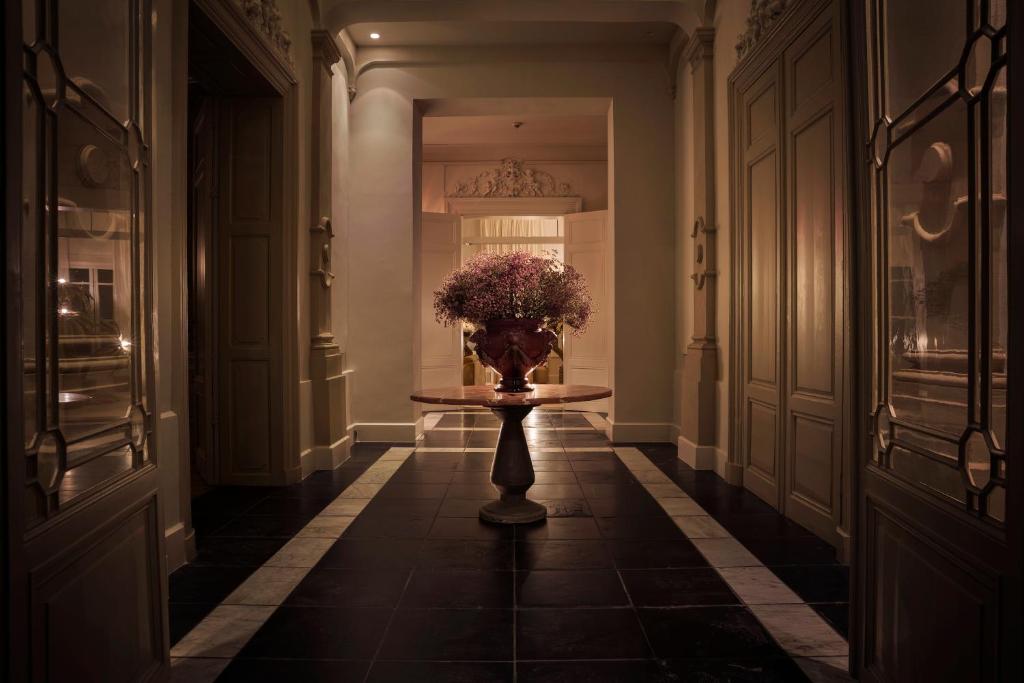 a hallway with a vase of flowers on a table at Hotel Van Cleef in Bruges