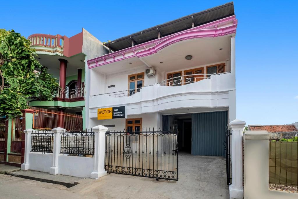 a white building with a gate in front of it at OYO Life 2412 Mandala Residence in Pundong