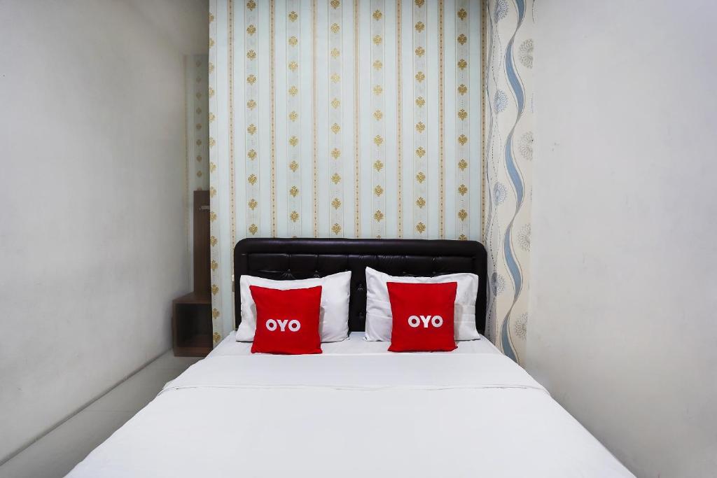 Rúm í herbergi á OYO D'lima Guest House Sub