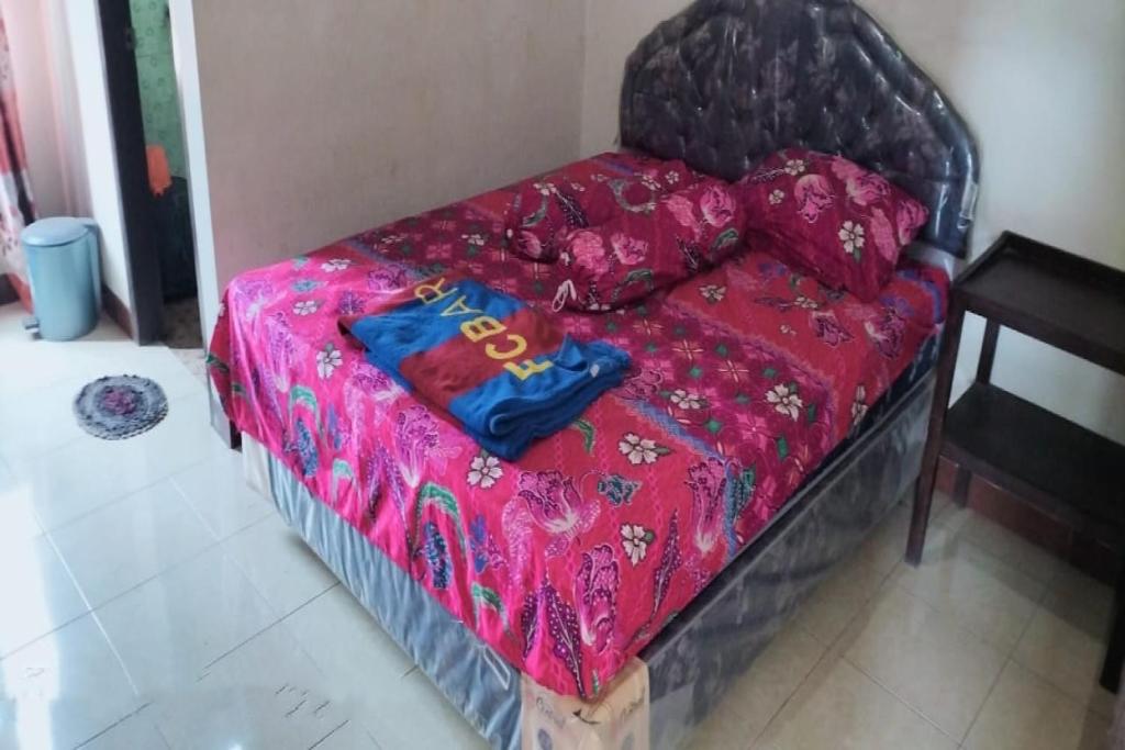a bed in a room with a pink blanket at Hotel O Aida Lestari in Sebulu