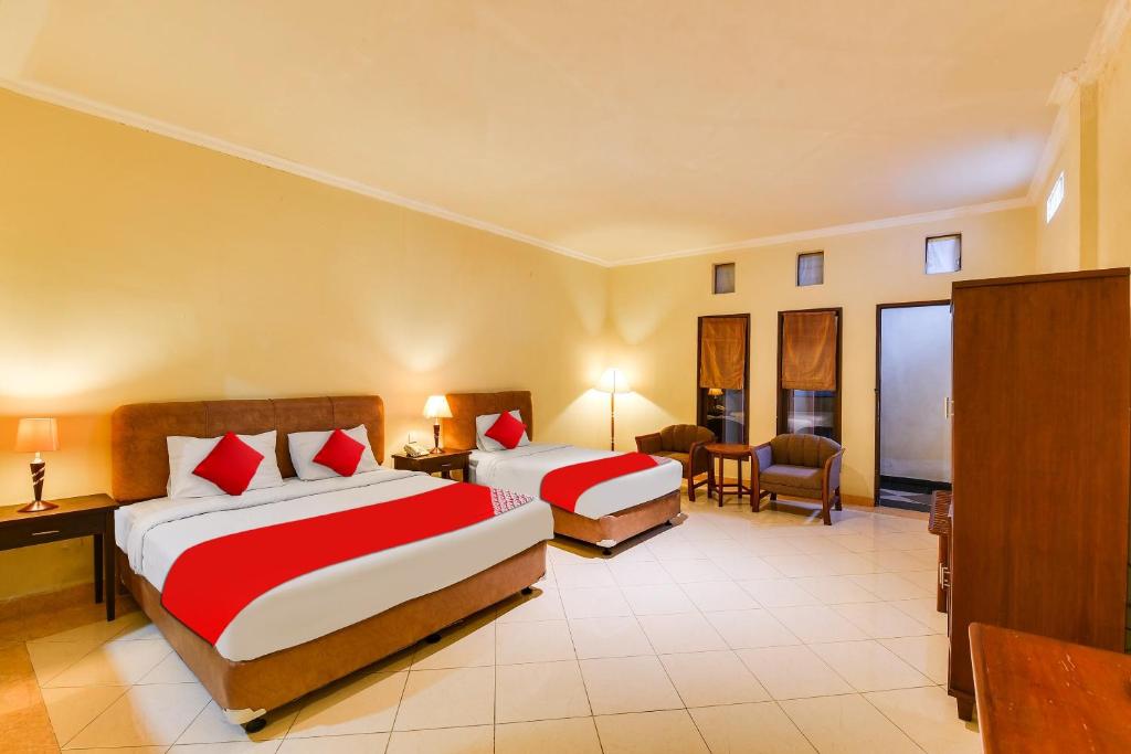 Postel nebo postele na pokoji v ubytování Super OYO Townhouse Oak Maxi Hotel Legian