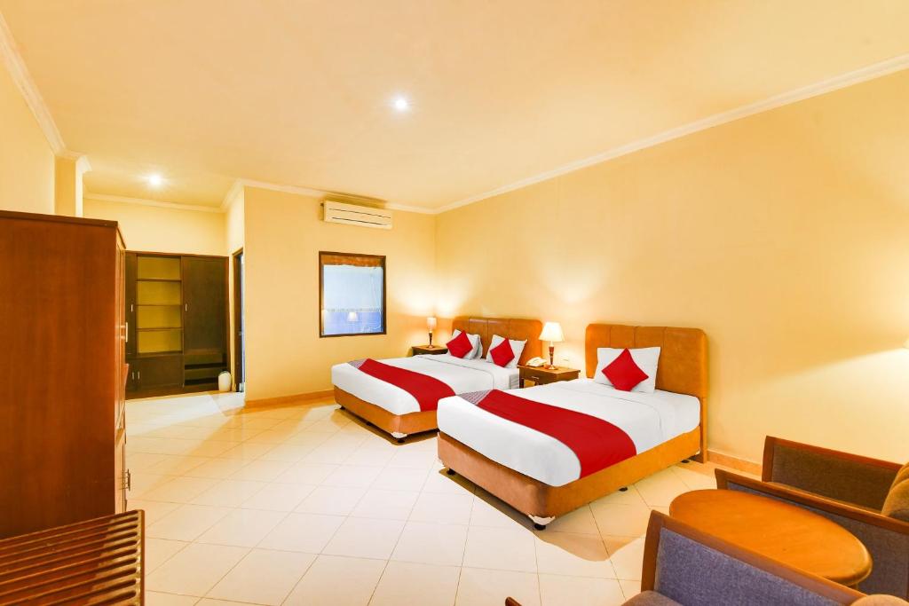 Postel nebo postele na pokoji v ubytování Super OYO Townhouse Oak Maxi Hotel Legian