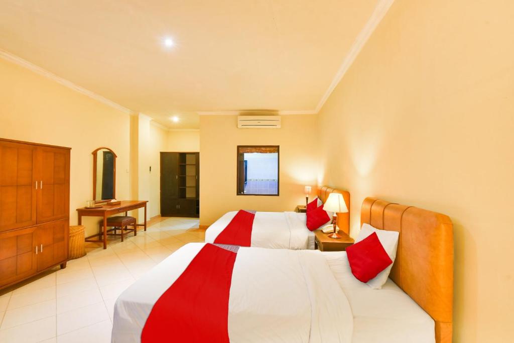 Postel nebo postele na pokoji v ubytování Super OYO Townhouse Oak Maxi Hotel Legian