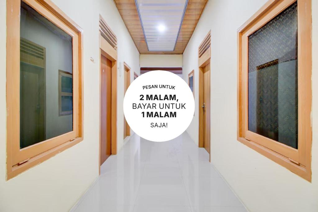 a hallway with windows and a sign that says mauritian bazar at Capital O Guest House Kpri Sejahtera in Purwokerto