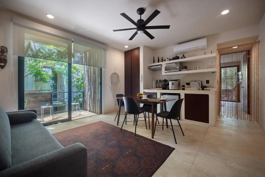 een woonkamer met een plafondventilator en een tafel en stoelen bij Charming Tulum Getaway in Prime Location in Tulum