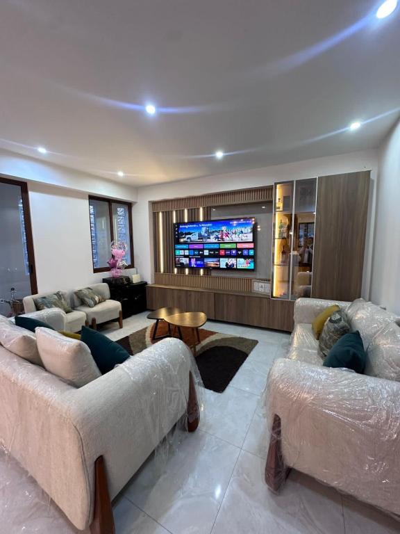 a living room with couches and a flat screen tv at Vale's Cottage in Huaraz
