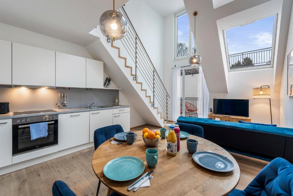 a kitchen and living room with a wooden table and blue chairs at Hillside Living Vienna in Vienna
