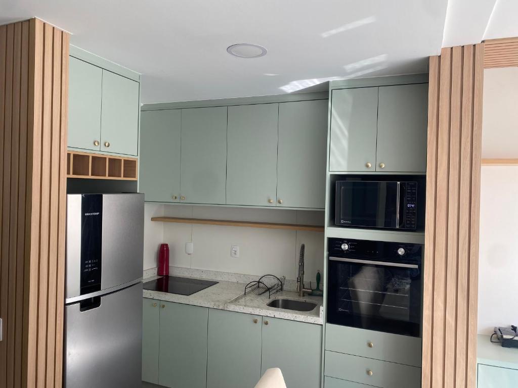 a kitchen with white cabinets and stainless steel appliances at Apartamento Congonhas 1308 torre suite in Sao Paulo