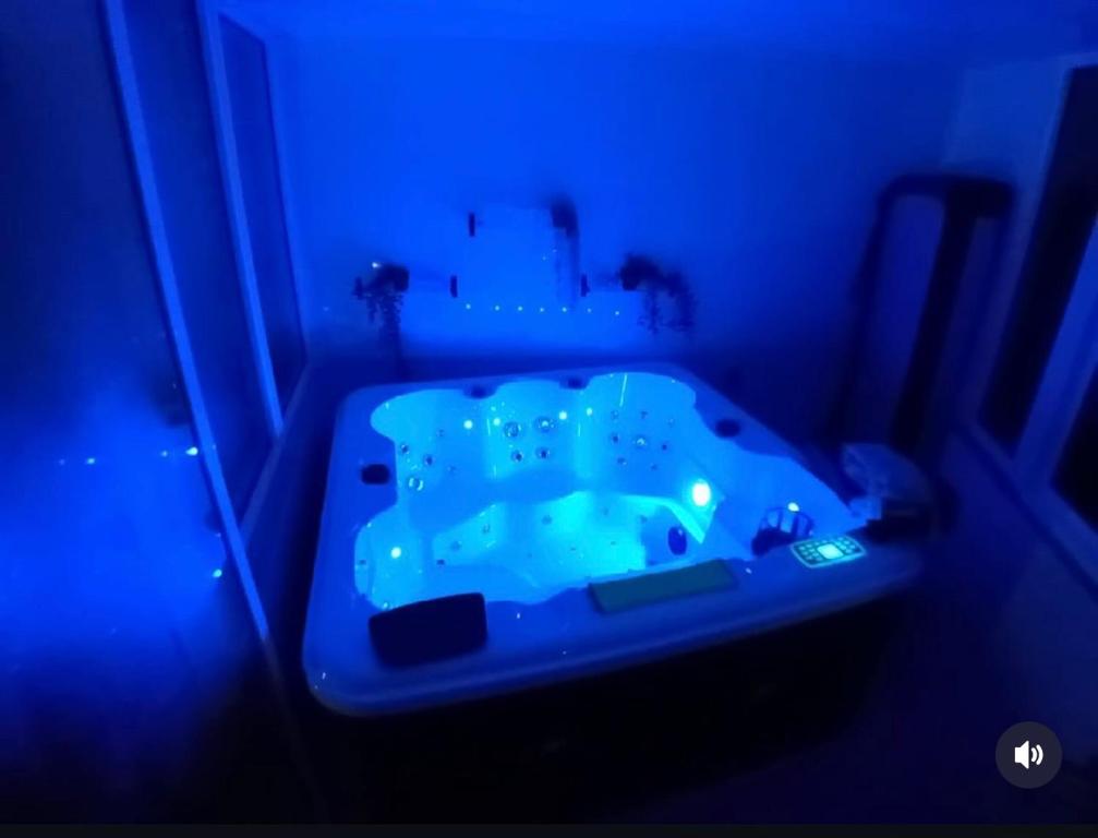 a blue bathroom with a tub in a dark room at Best Gerês village in São Pedro