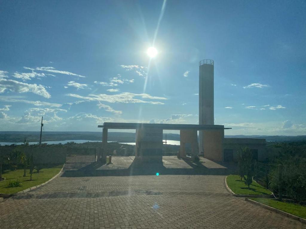 a monument with the sun in the sky at Los Arboles - Quarto com Banheiro in Alexânia